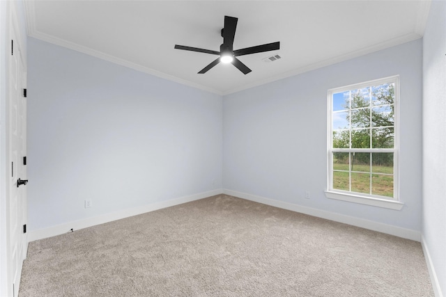 carpeted empty room featuring crown molding, visible vents, ceiling fan, and baseboards