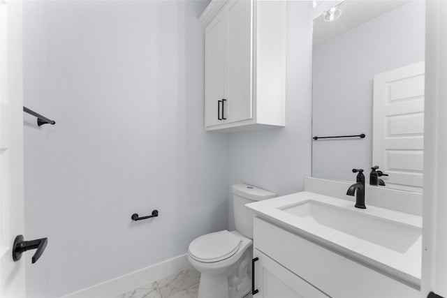 bathroom with toilet, marble finish floor, baseboards, and vanity