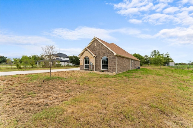 view of property exterior with a yard and brick siding