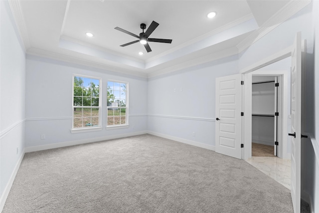 unfurnished bedroom featuring a raised ceiling, crown molding, carpet floors, and recessed lighting