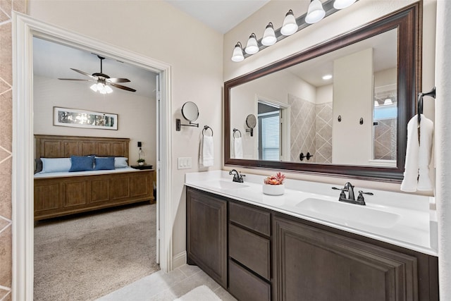full bath with double vanity, a sink, ceiling fan, and ensuite bath