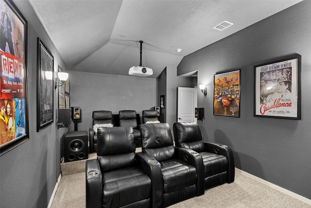 home theater with carpet flooring, visible vents, a textured wall, and lofted ceiling
