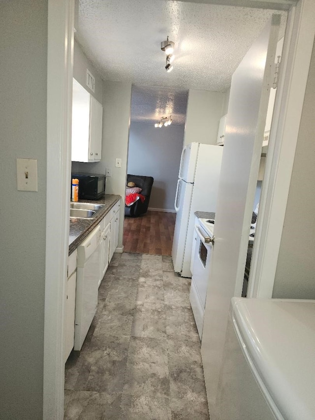 4614 Country Creek Dr Unit 1167, Dallas, TX 75236 - kitchen featuring white cabinetry, dark countertops, a textured ceiling, and white appliances