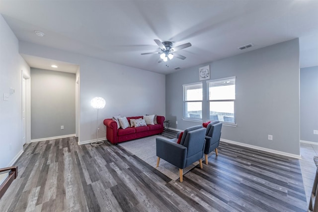 living area with dark wood-type flooring, ceiling fan, baseboards, and visible vents