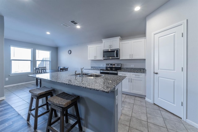 kitchen featuring a breakfast bar area, visible vents, a sink, and appliances with stainless steel finishes