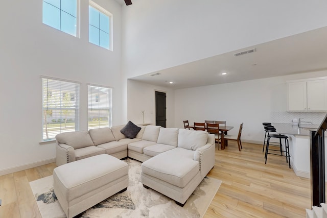 2812 Bluejack Rd, Mckinney, TX 75071 - living area featuring a towering ceiling, baseboards, light wood-type flooring, and visible vents