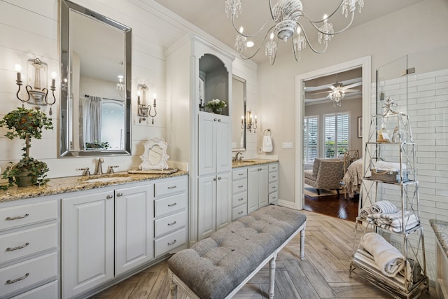1318 Amsterdam Ct, Granbury, TX 76048 - bathroom with ensuite bathroom, a chandelier, two vanities, baseboards, and crown molding