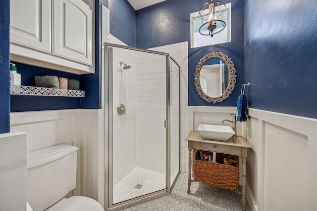 1318 Amsterdam Ct, Granbury, TX 76048 - full bath featuring wainscoting, a shower stall, toilet, a decorative wall, and vanity