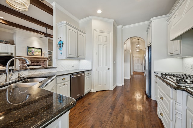 1318 Amsterdam Ct, Granbury, TX 76048 - kitchen with a sink, stainless steel appliances, arched walkways, a ceiling fan, and dark stone countertops