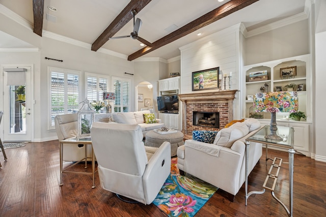 1318 Amsterdam Ct, Granbury, TX 76048 - living room with ceiling fan, beam ceiling, a fireplace, arched walkways, and dark wood-style floors