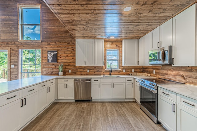 kitchen featuring white cabinets, stainless steel appliances, light wood finished floors, wood ceiling, and a sink