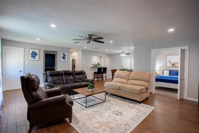 living area featuring dark wood-type flooring, ceiling fan, recessed lighting, and baseboards