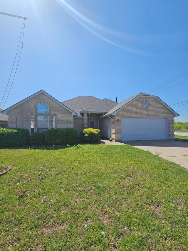 ranch-style home featuring brick siding, a garage, a front yard, and concrete driveway