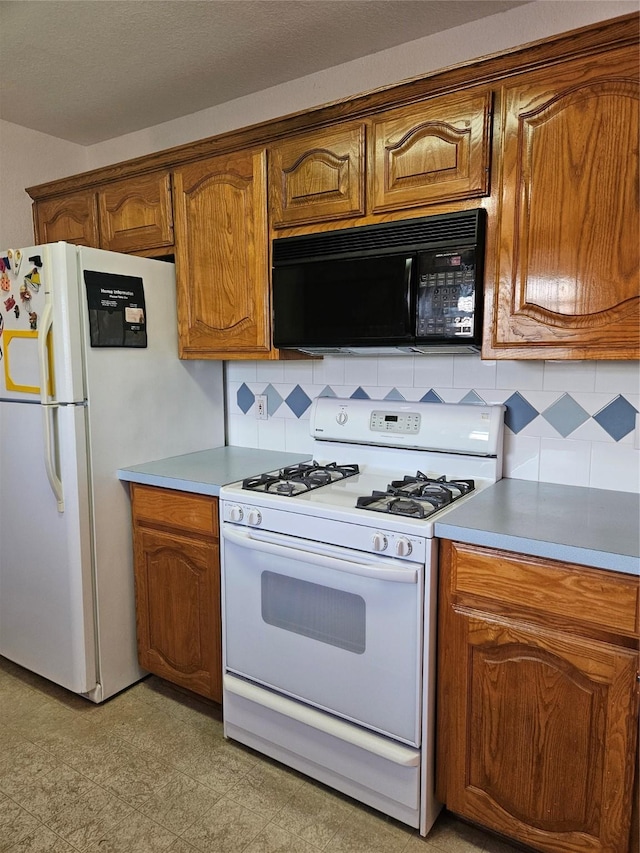kitchen with brown cabinetry, light countertops, backsplash, and white appliances