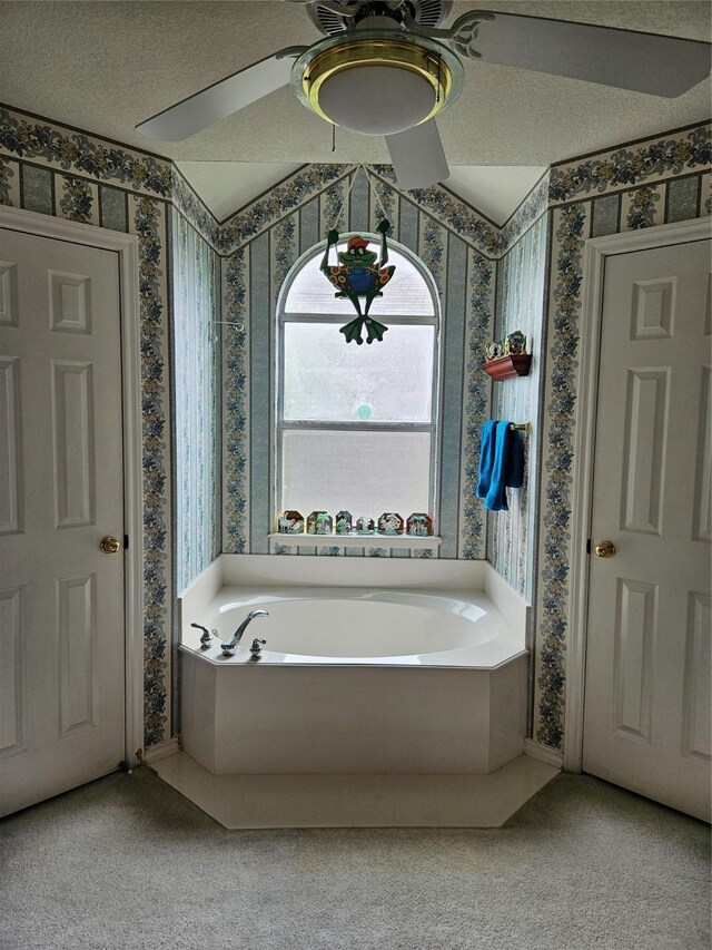 bathroom with wallpapered walls, ceiling fan, and a garden tub
