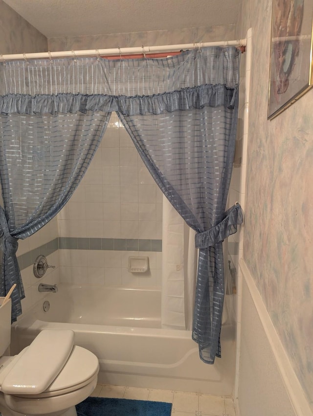 bathroom with tile patterned flooring, shower / bath combo with shower curtain, and toilet