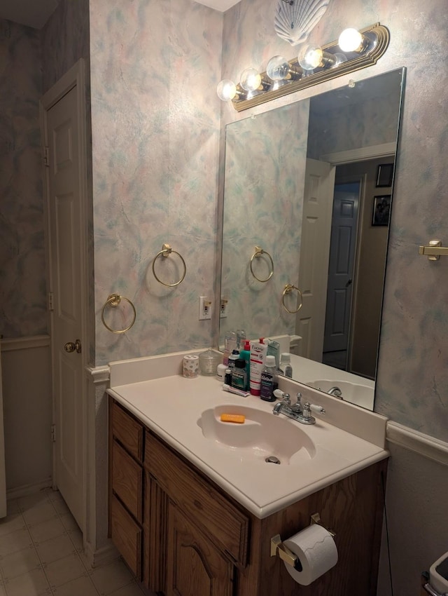 bathroom featuring tile patterned floors, vanity, and wallpapered walls