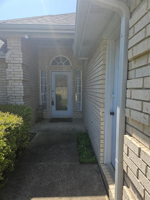 doorway to property with brick siding