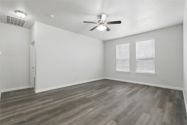 unfurnished room featuring visible vents, baseboards, a ceiling fan, and dark wood finished floors