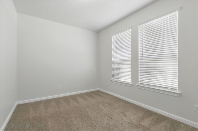 carpeted empty room with baseboards