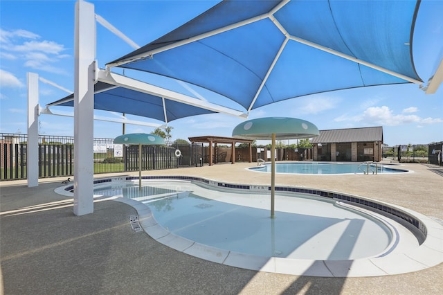community pool featuring a jacuzzi, a patio, and fence