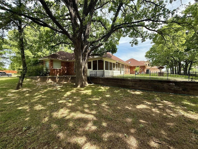 view of yard with fence and a sunroom