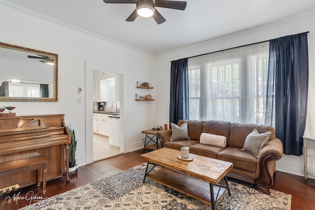 living room with baseboards, ornamental molding, ceiling fan, and dark wood-style flooring
