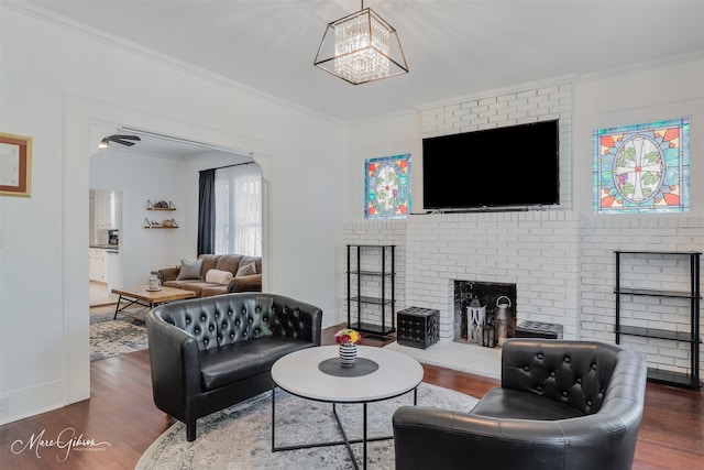 living room with wood finished floors, a fireplace, and ornamental molding