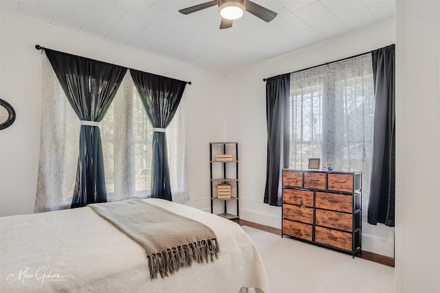 carpeted bedroom with ornamental molding, baseboards, and a ceiling fan