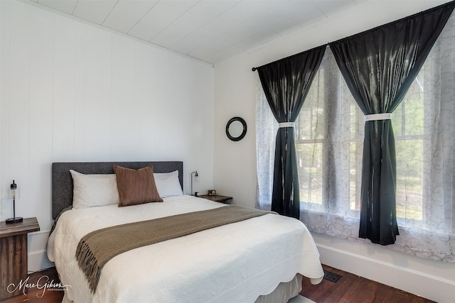 bedroom featuring multiple windows and wood finished floors