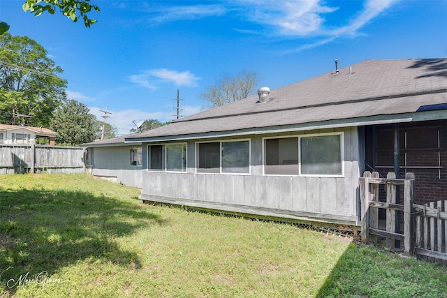 back of property featuring a yard and fence