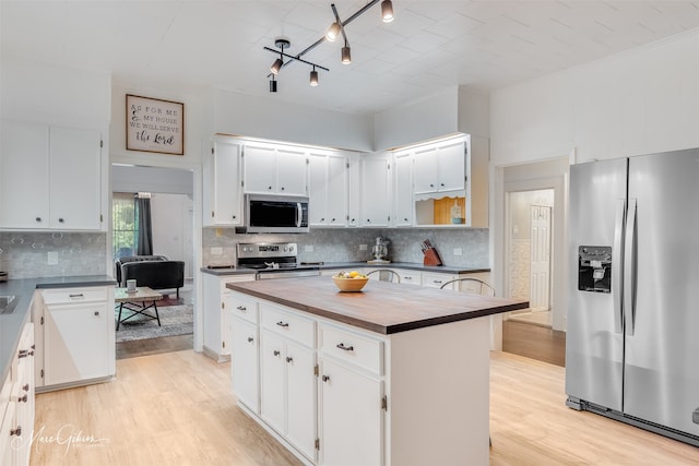 kitchen featuring stainless steel appliances, light wood-style flooring, tasteful backsplash, wood counters, and a kitchen island
