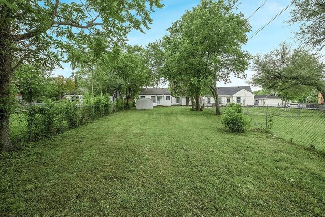 1507 Newport Ave, Dallas, TX 75224 - view of yard with a fenced backyard, an outdoor structure, and a shed