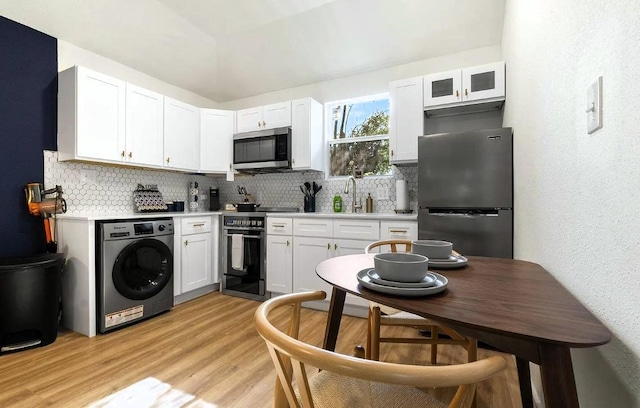 1507 Newport Ave, Dallas, TX 75224 - kitchen featuring decorative backsplash, stainless steel appliances, white cabinetry, light wood-style flooring, and washer / clothes dryer