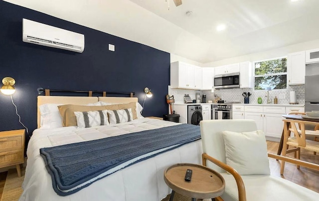 1507 Newport Ave, Dallas, TX 75224 - bedroom with lofted ceiling, light wood-style floors, freestanding refrigerator, a wall mounted AC, and washer / clothes dryer