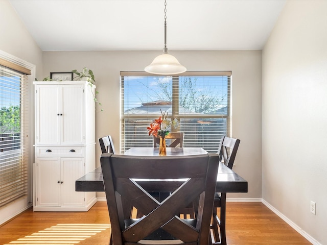dining area with light wood-type flooring, a healthy amount of sunlight, and baseboards