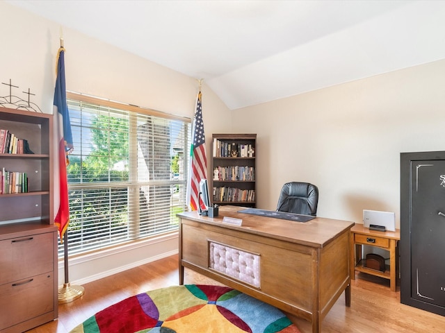 office space featuring lofted ceiling, baseboards, and light wood finished floors