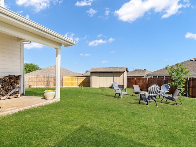 view of yard featuring a patio, a fenced backyard, an outbuilding, and a shed