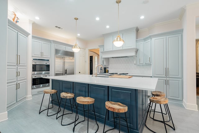 kitchen featuring arched walkways, visible vents, decorative backsplash, a breakfast bar, and appliances with stainless steel finishes