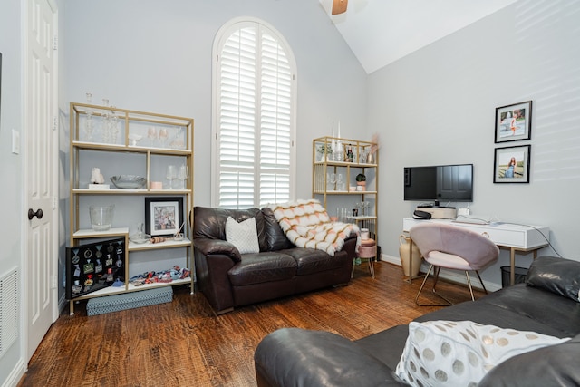 living area with wood finished floors and high vaulted ceiling
