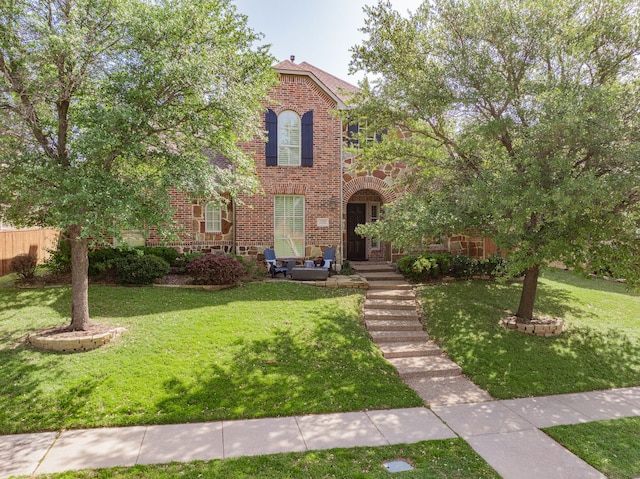view of front facade featuring brick siding and a front yard