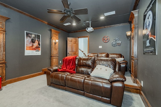 carpeted home theater room with ceiling fan, baseboards, visible vents, and ornamental molding