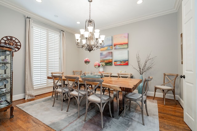 dining space featuring a notable chandelier, baseboards, crown molding, and wood finished floors