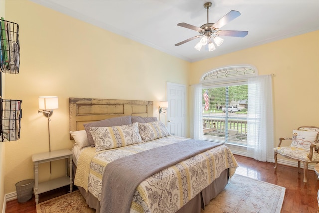 bedroom with a ceiling fan, baseboards, ornamental molding, and wood finished floors