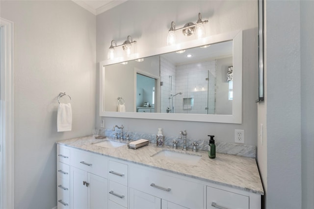 full bath featuring a sink, a shower stall, double vanity, and crown molding
