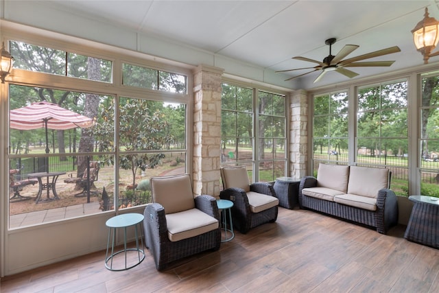 sunroom / solarium with a ceiling fan, a healthy amount of sunlight, and an outdoor living space