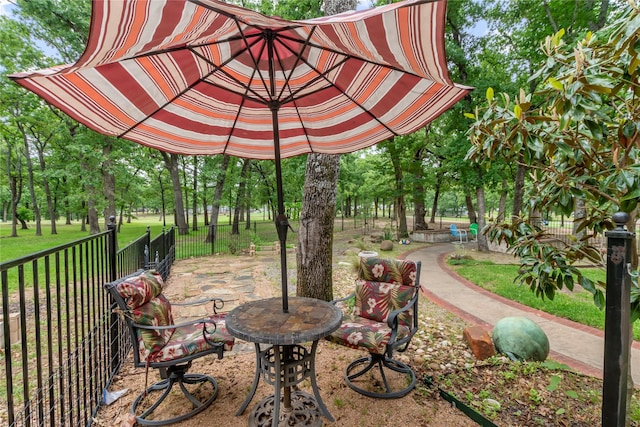 view of home's community with fence, a lawn, and a patio