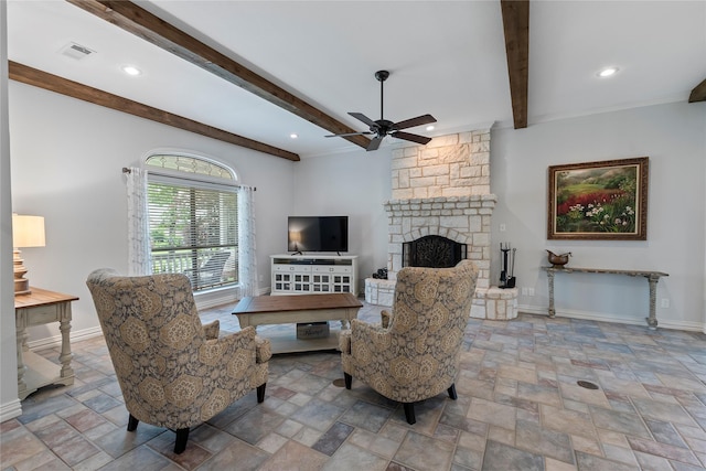 living area featuring beamed ceiling, a ceiling fan, visible vents, and stone finish flooring