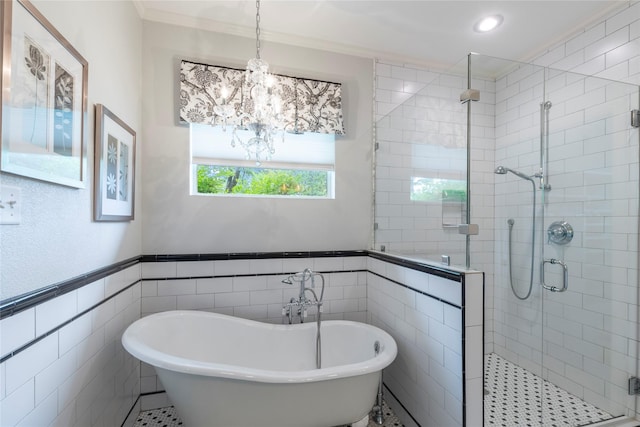 full bathroom featuring tile walls, a soaking tub, a notable chandelier, and a stall shower