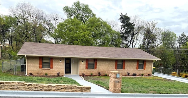 single story home with a gate, brick siding, fence, and a front yard